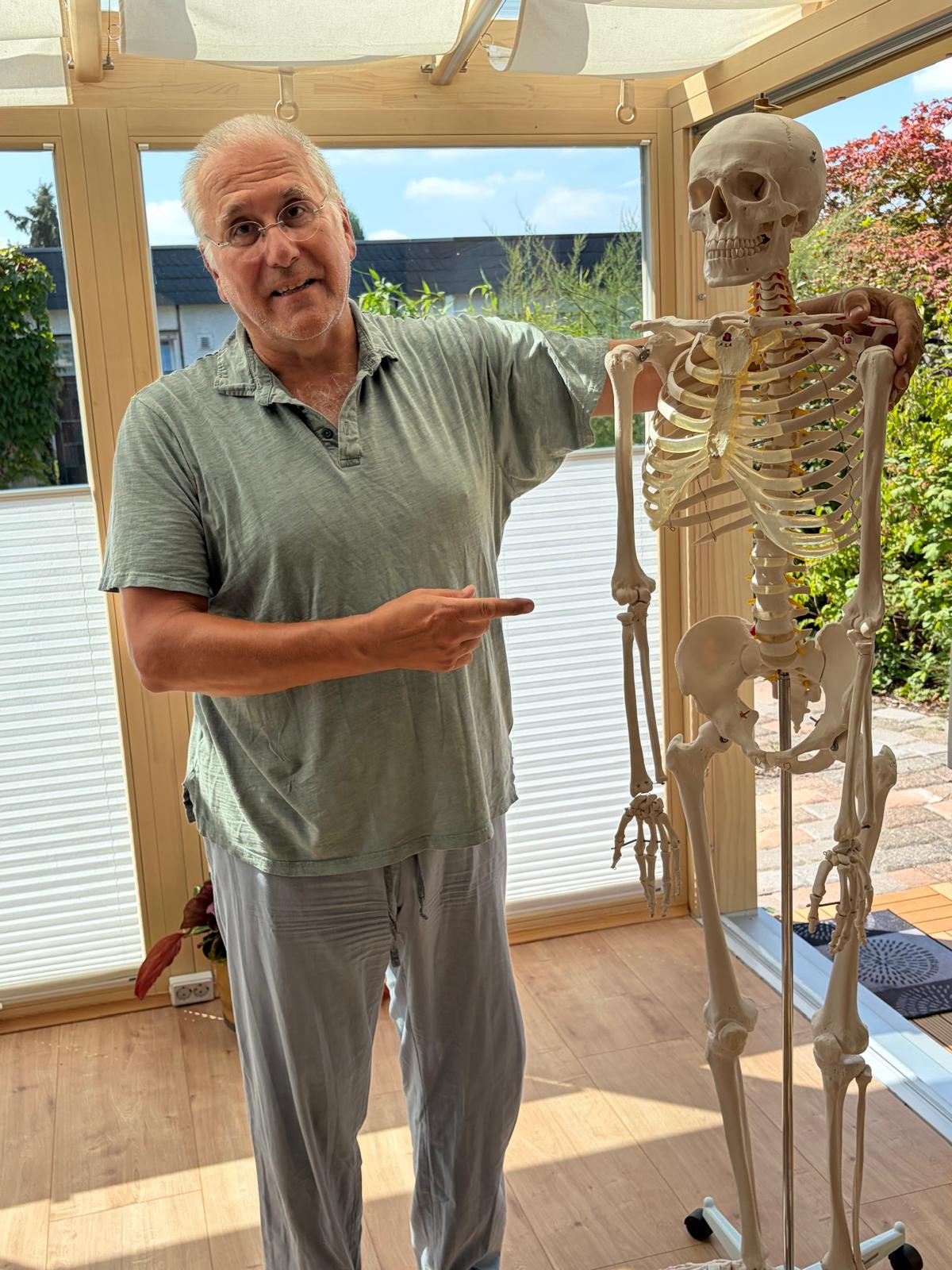 Gunnar Hecken erklärt am Skelettmodell die Zusammenhänge von Bewegung und Schmerz